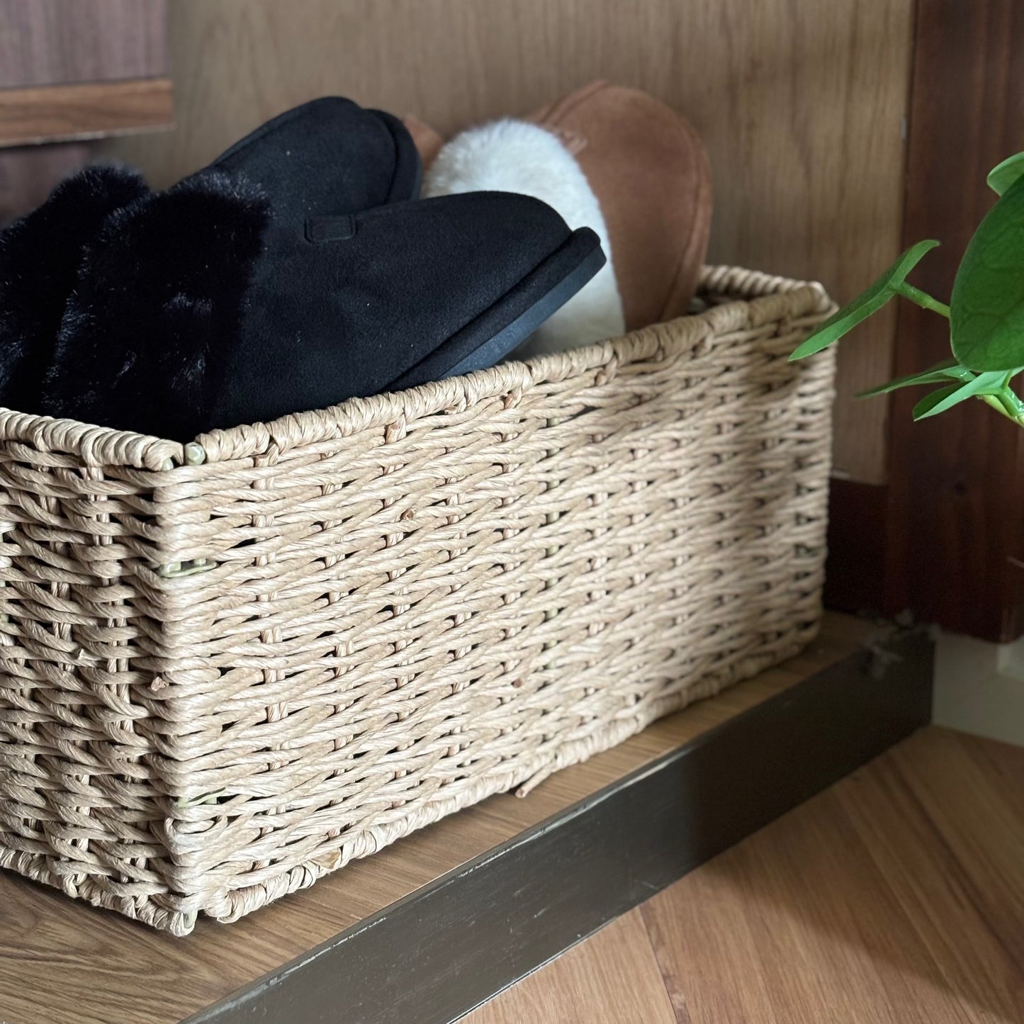 手編みの折り畳み式ペーパーコードバスケットの中にスリッパを入れている様子