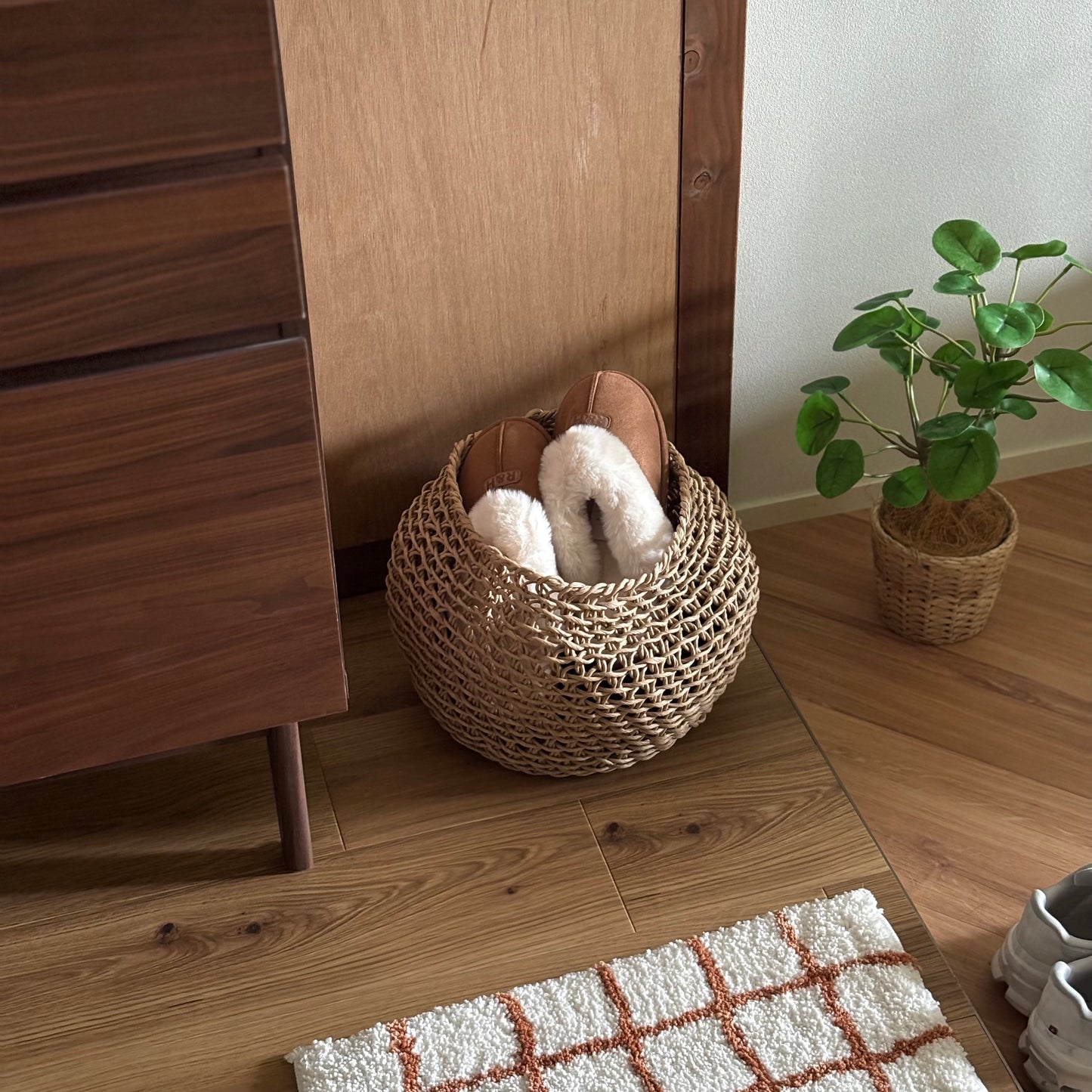 ラウンドのペーパーコードバスケットの中にスリッパを入れて玄関に置いている様子