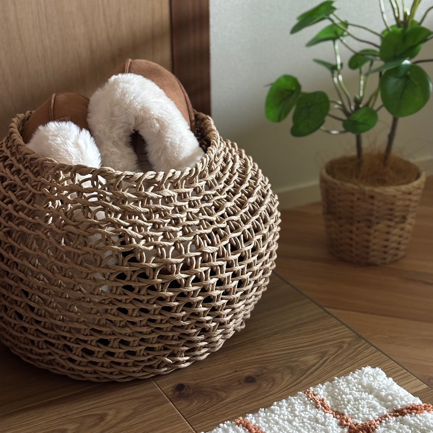 ラウンドのペーパーコードバスケットの中にスリッパを入れて玄関に置いている様子