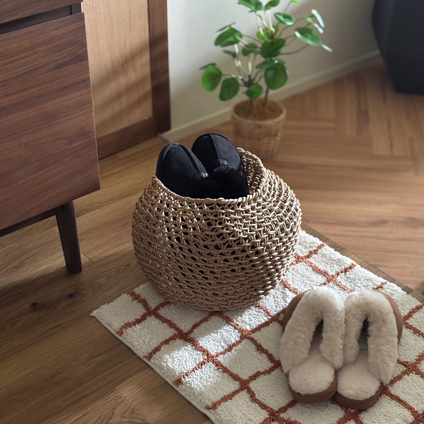 ラウンドのペーパーコードバスケットにスリッパを入れて玄関に置いている様子