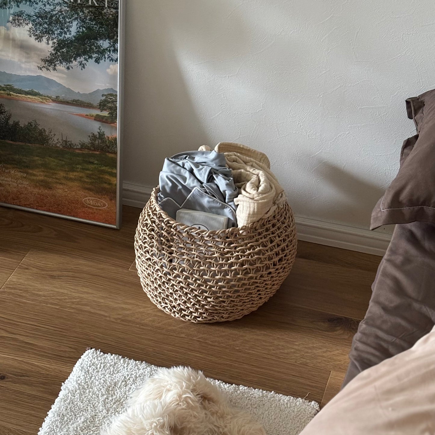 ラウンドのペーパーコードバスケットの中にパジャマやブランケットを入れている様子