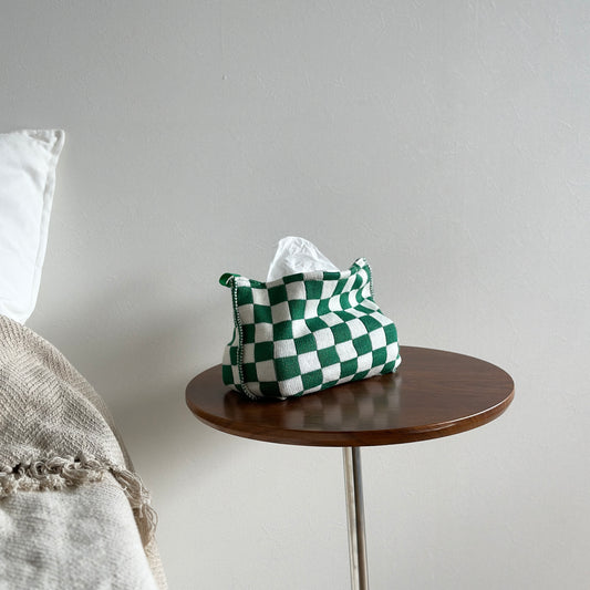 グリーンのチェック柄のニットティッシュケースがベッド横の茶色のテーブルの上に置かれている様子