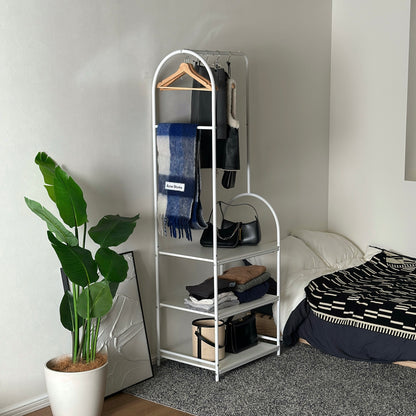 3段棚のハンガーラックをベッド横に置いている様子