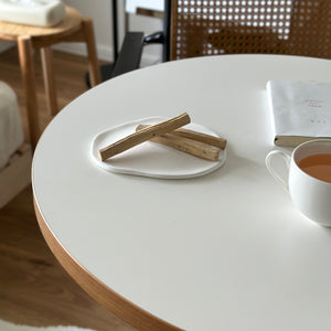 白い陶器のプレートにのった三本の薄茶色の木製スティックが石膏プレートです。