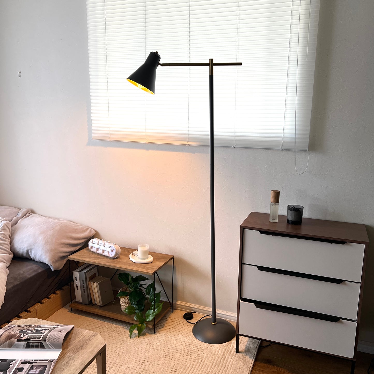 ブラックのスチール製のフロアライトを部屋に置いている様子