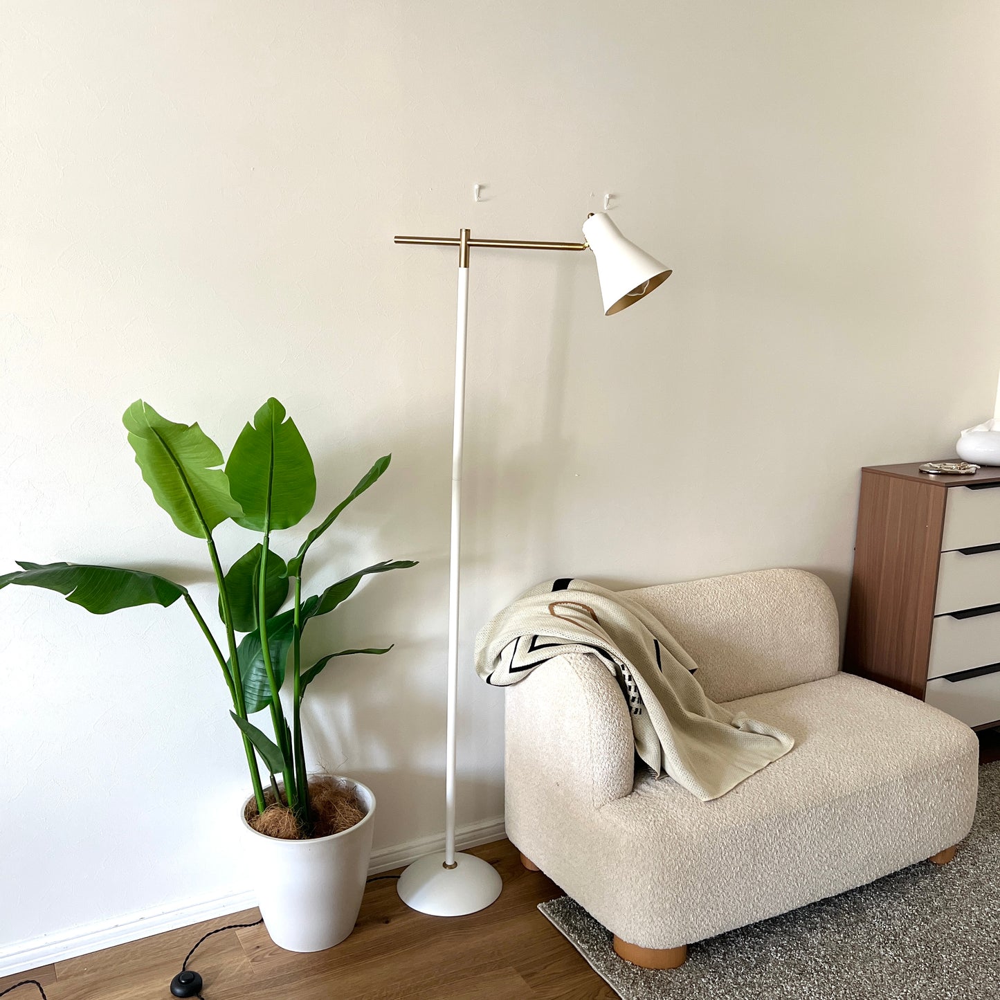 ホワイトのスチール製のフロアライトをソファ横に置いている様子