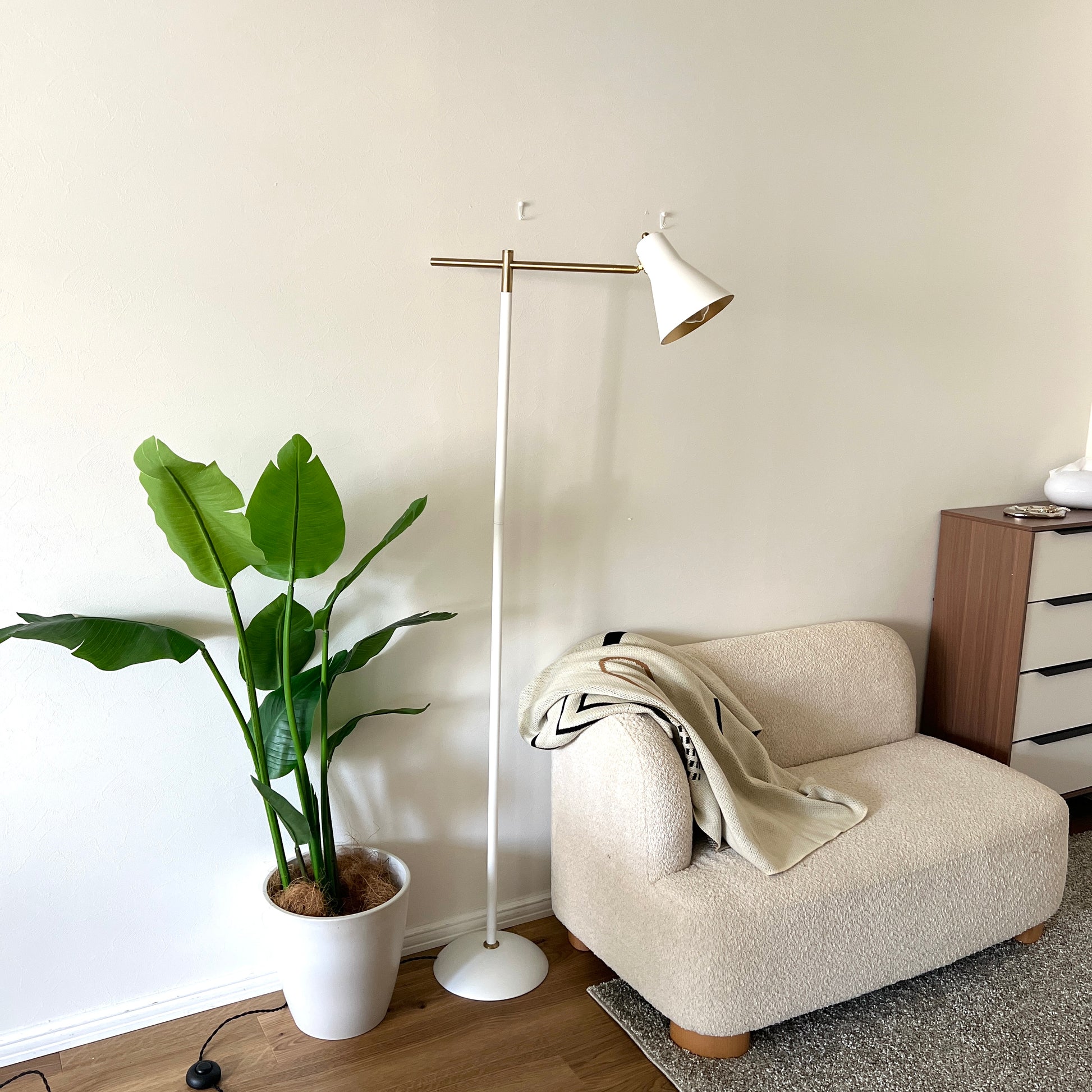 ホワイトのスチール製のフロアライトをソファ横に置いている様子