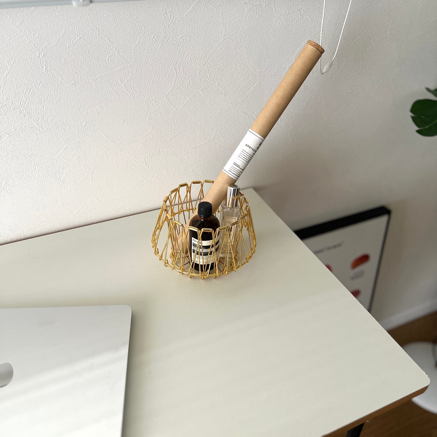 ゴールドのワイヤーバスケットの中にお香と香水が入っている様子