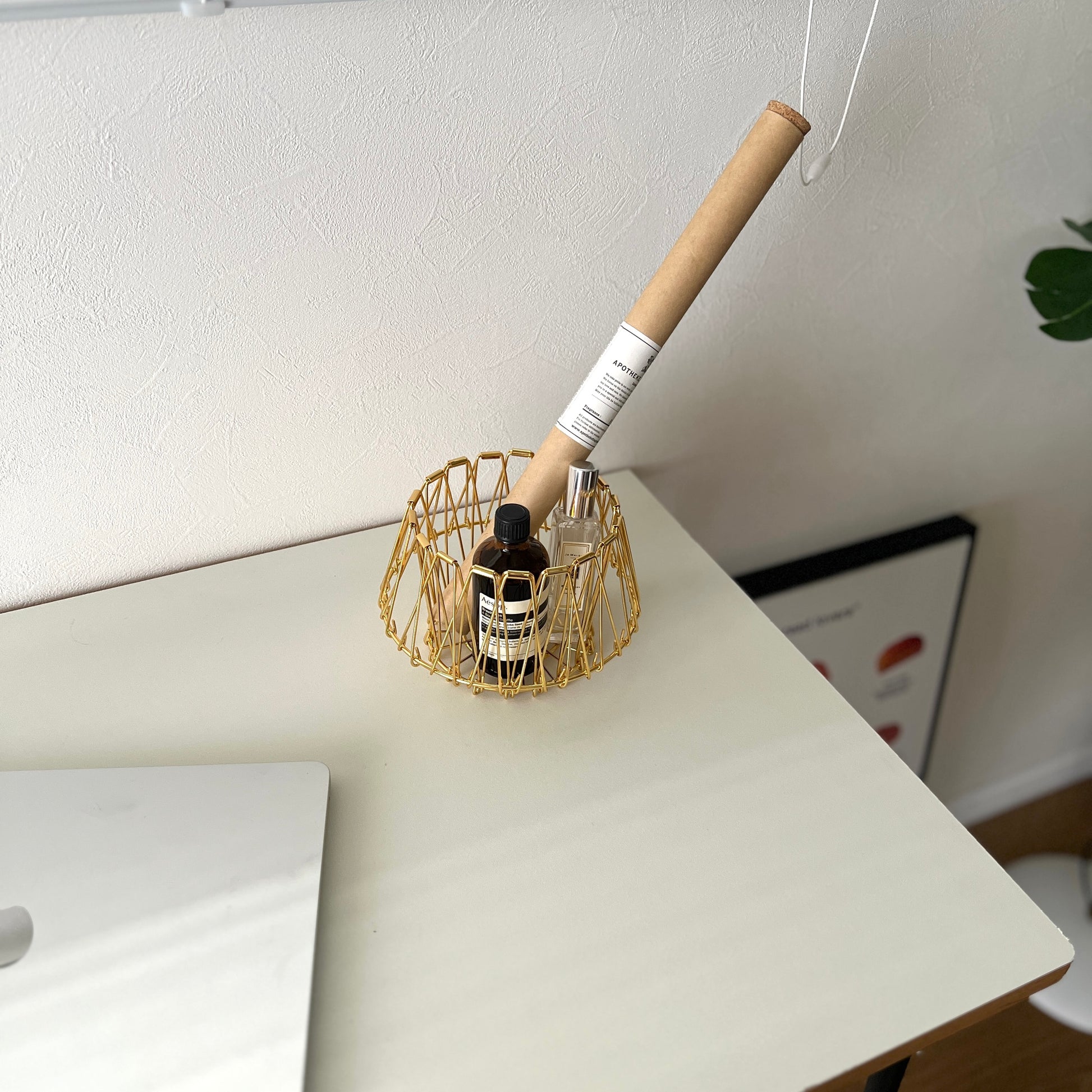 ゴールドのワイヤーバスケットの中にお香と香水が入っている様子