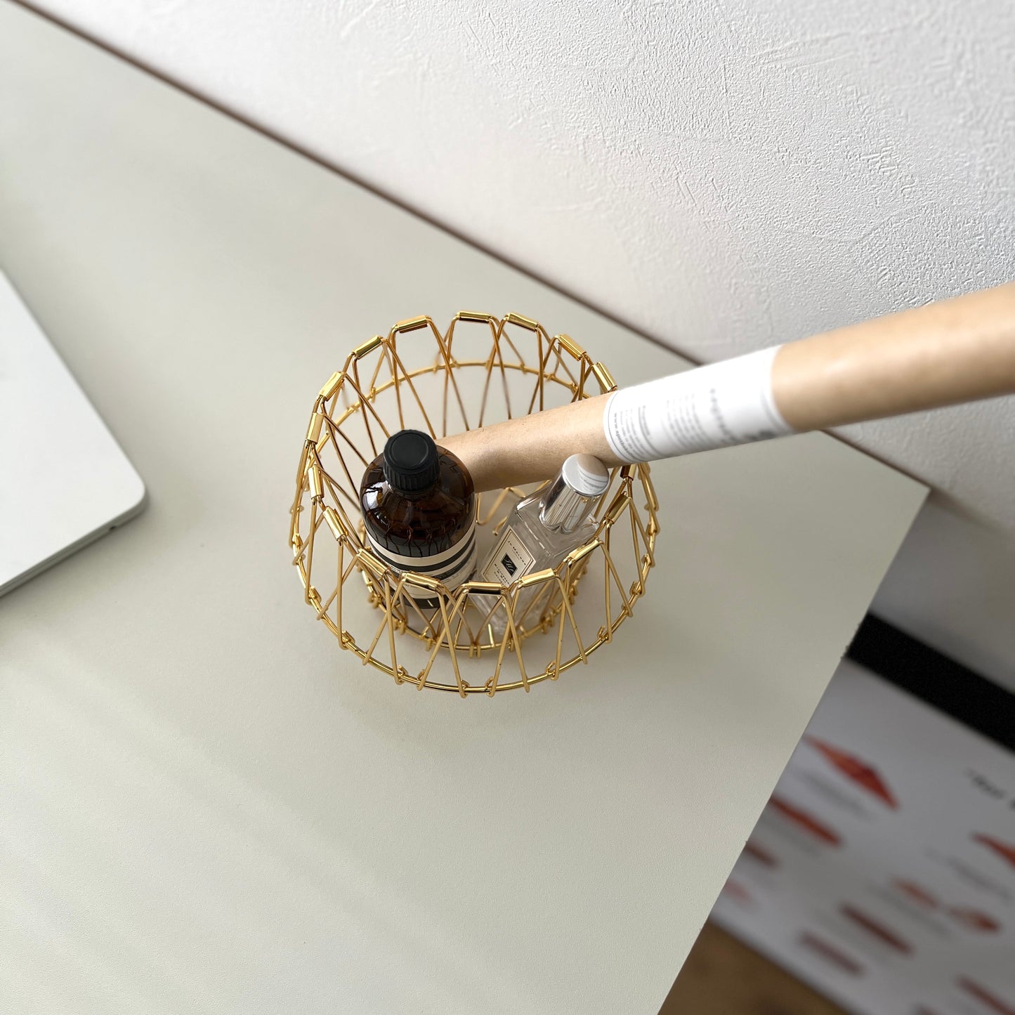 ゴールドのワイヤーバスケットの中に香水とお香が入っている様子