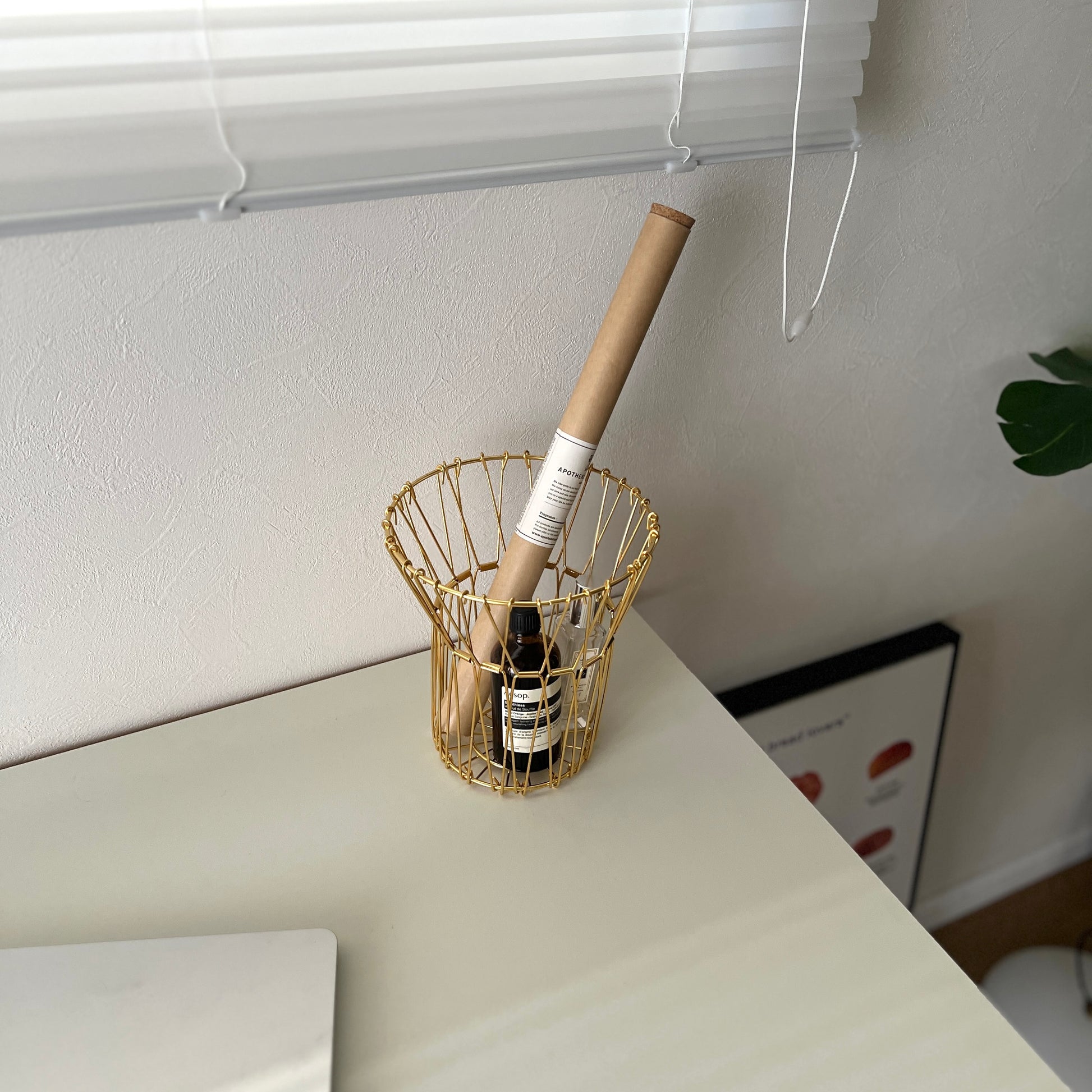 ゴールドのワイヤーバスケットの中にお香と香水が入っている様子