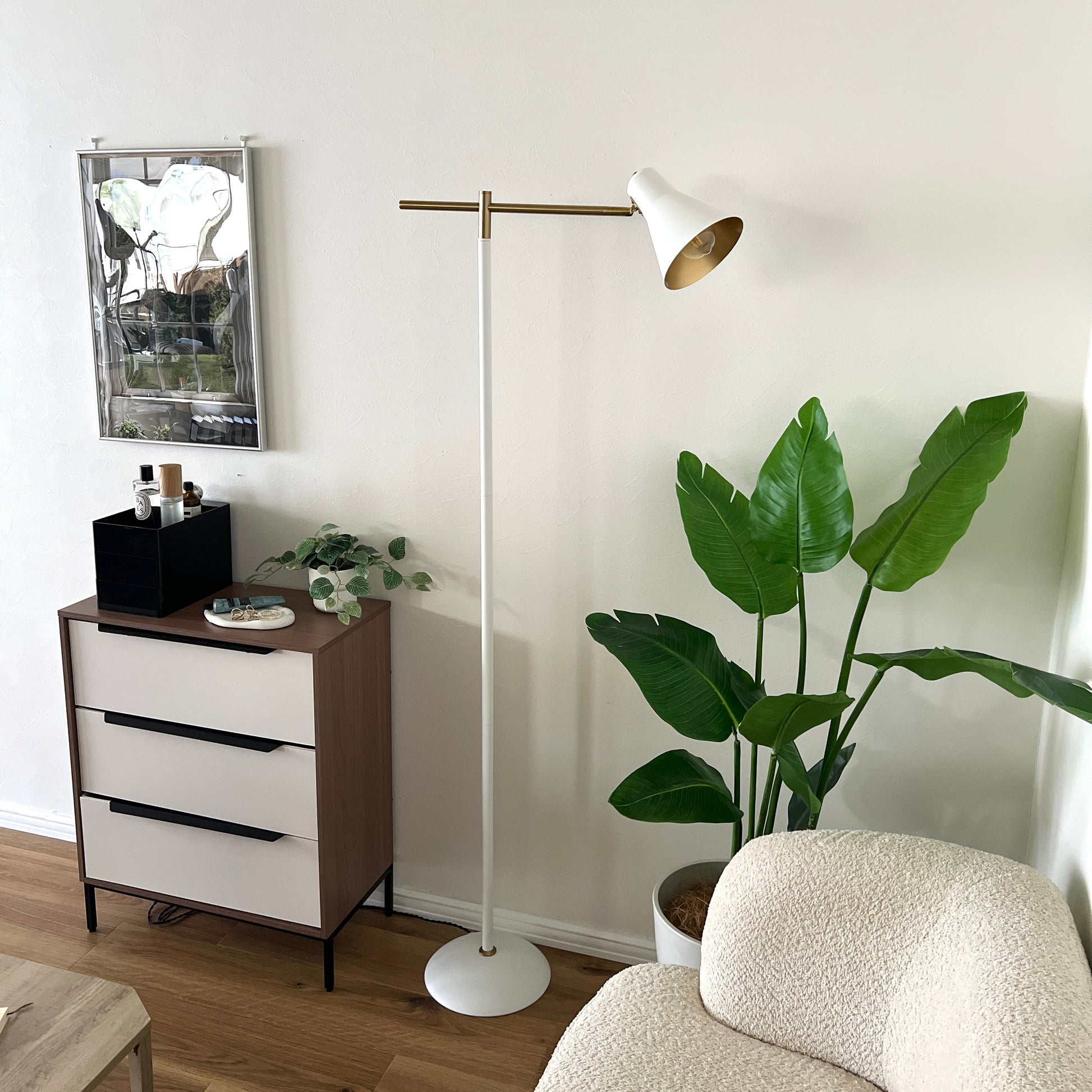 ホワイトのスチール製のフロアライトを植物の横に置いている様子