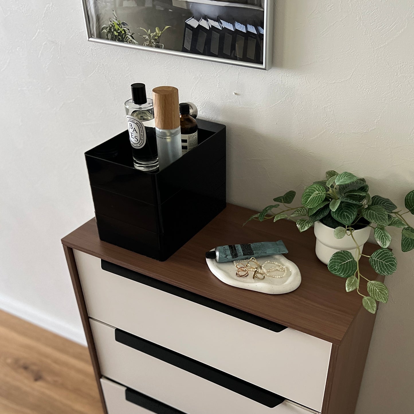 部屋のチェストの上に黒い3段の収納ケースが乗っている様子