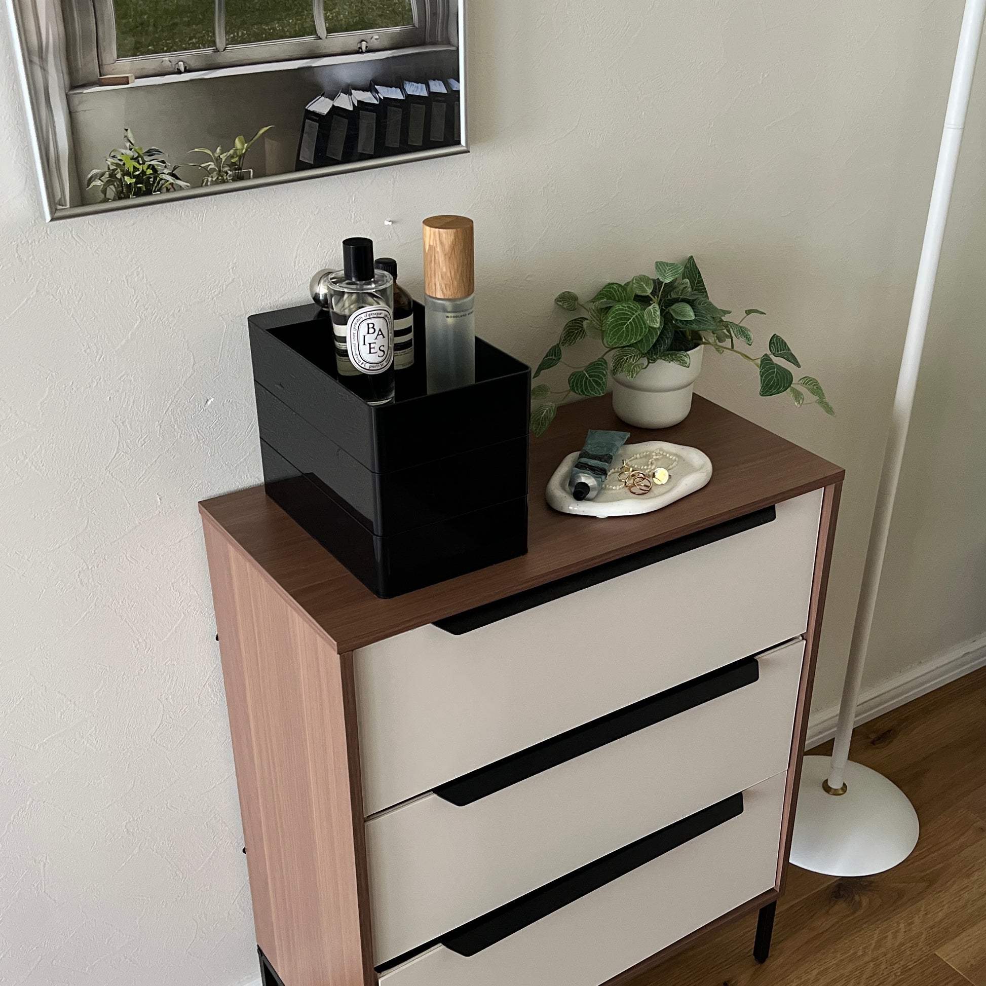 部屋の中でチェストの上に黒い3段の収納ケースが乗っている様子