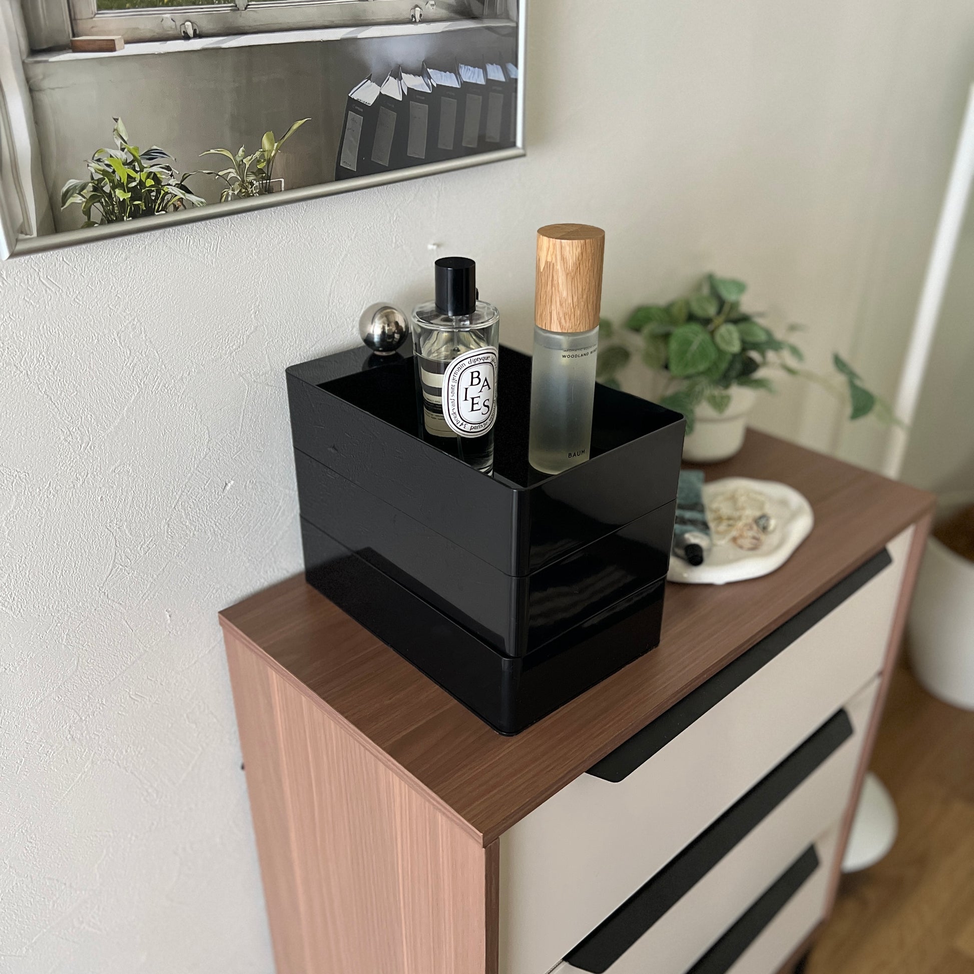 部屋のチェストの上に黒い3段の収納ケースが乗っている様子