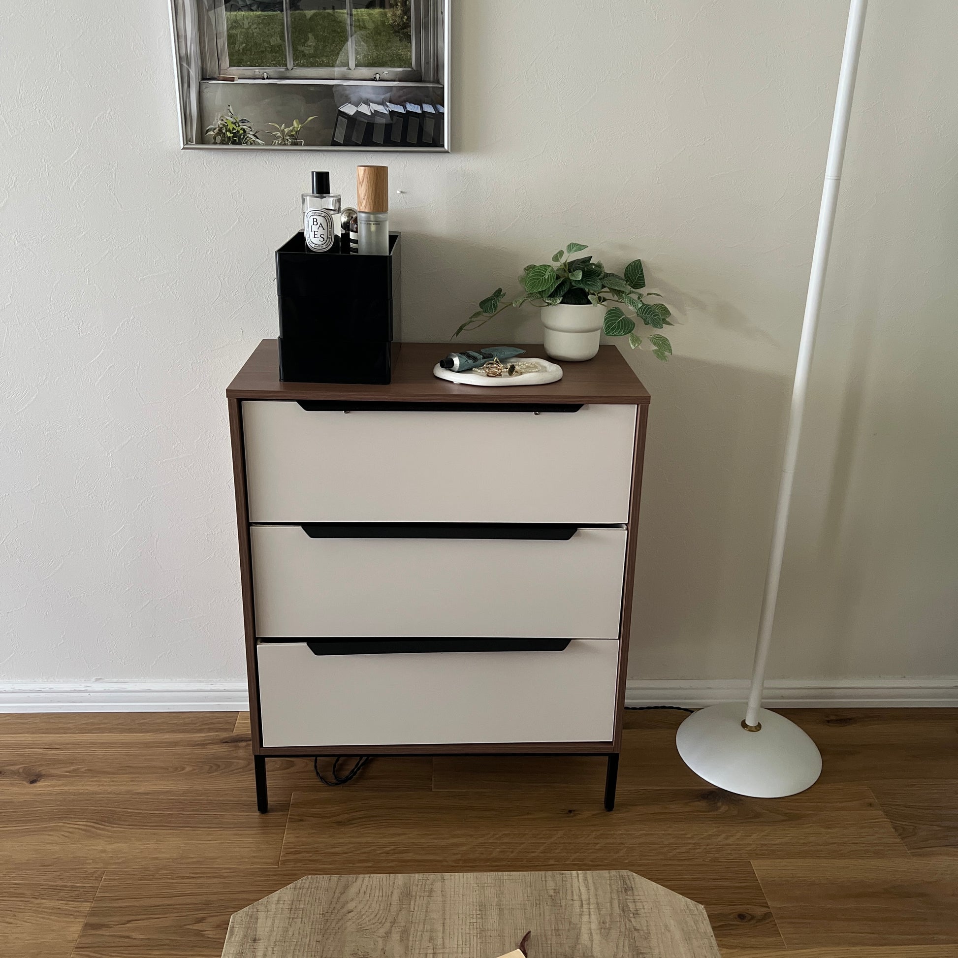 部屋の中でチェストの上に黒い3段の収納ケースが乗っている様子