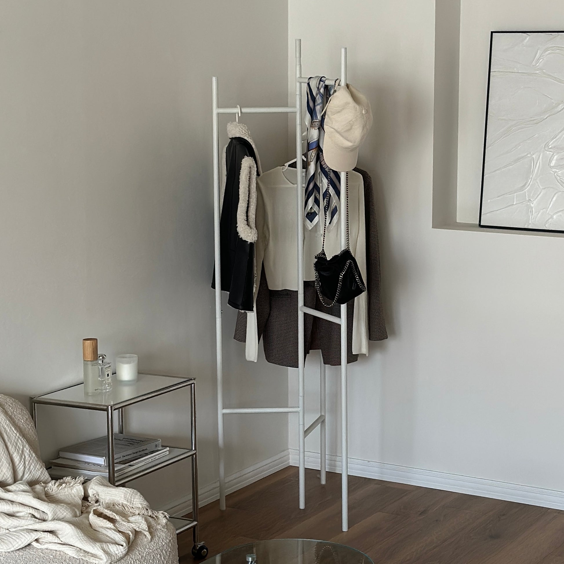 部屋の中で折り畳めるスタイリッシュなパーテーションハンガーに洋服やバッグが飾ってある様子