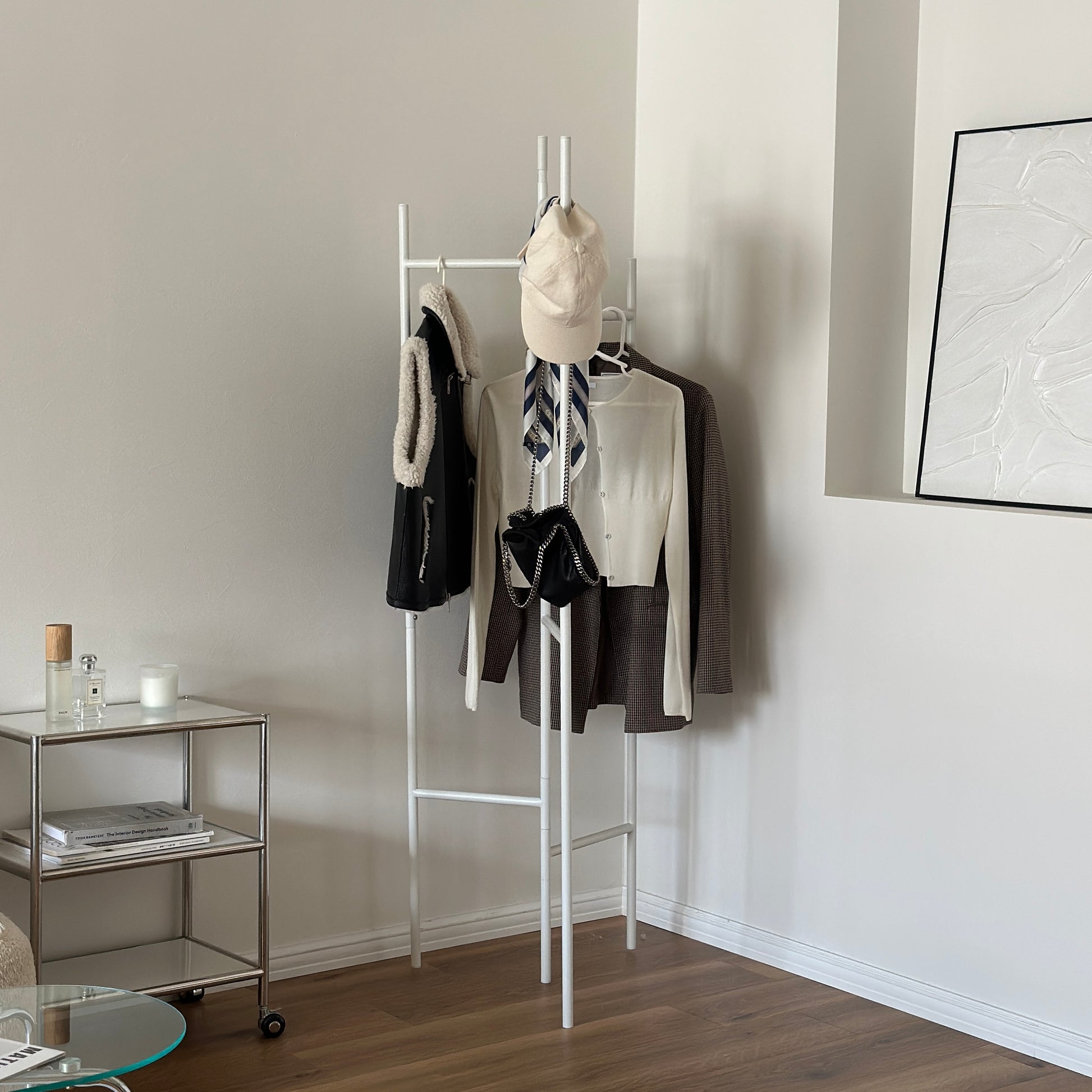 部屋の中で折り畳めるスタイリッシュなパーテーションハンガーに洋服やバッグが飾ってある様子