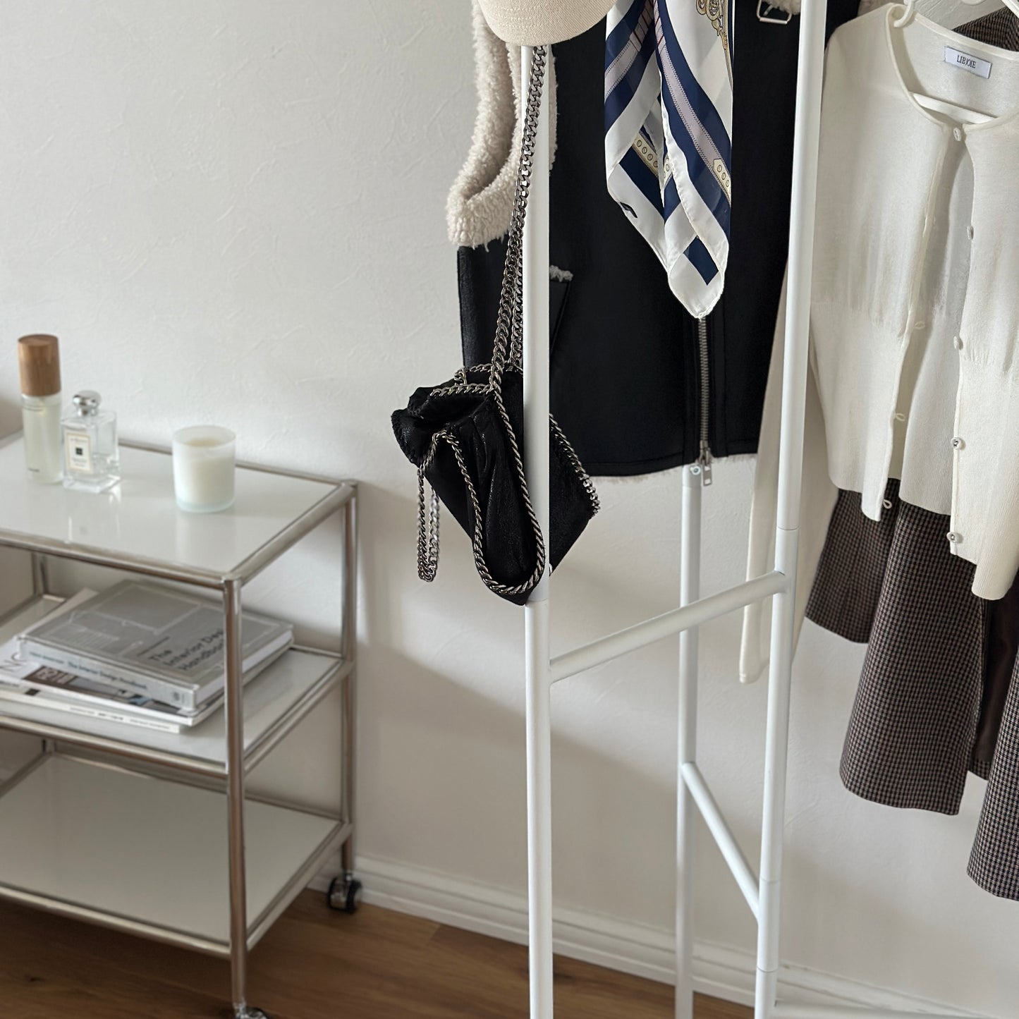 部屋の中で折り畳めるスタイリッシュなパーテーションハンガーに洋服やバッグが飾ってある様子