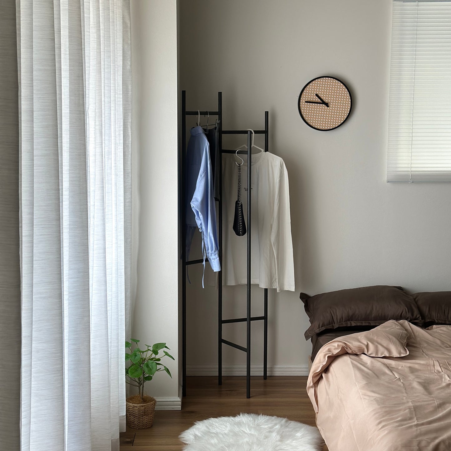部屋の中で折り畳めるスタイリッシュなパーテーションハンガーに洋服やバッグが飾ってある様子