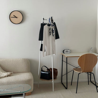 部屋の中で白いコンパクトでスタイリッシュなハンガーラックに洋服がかかっている様子