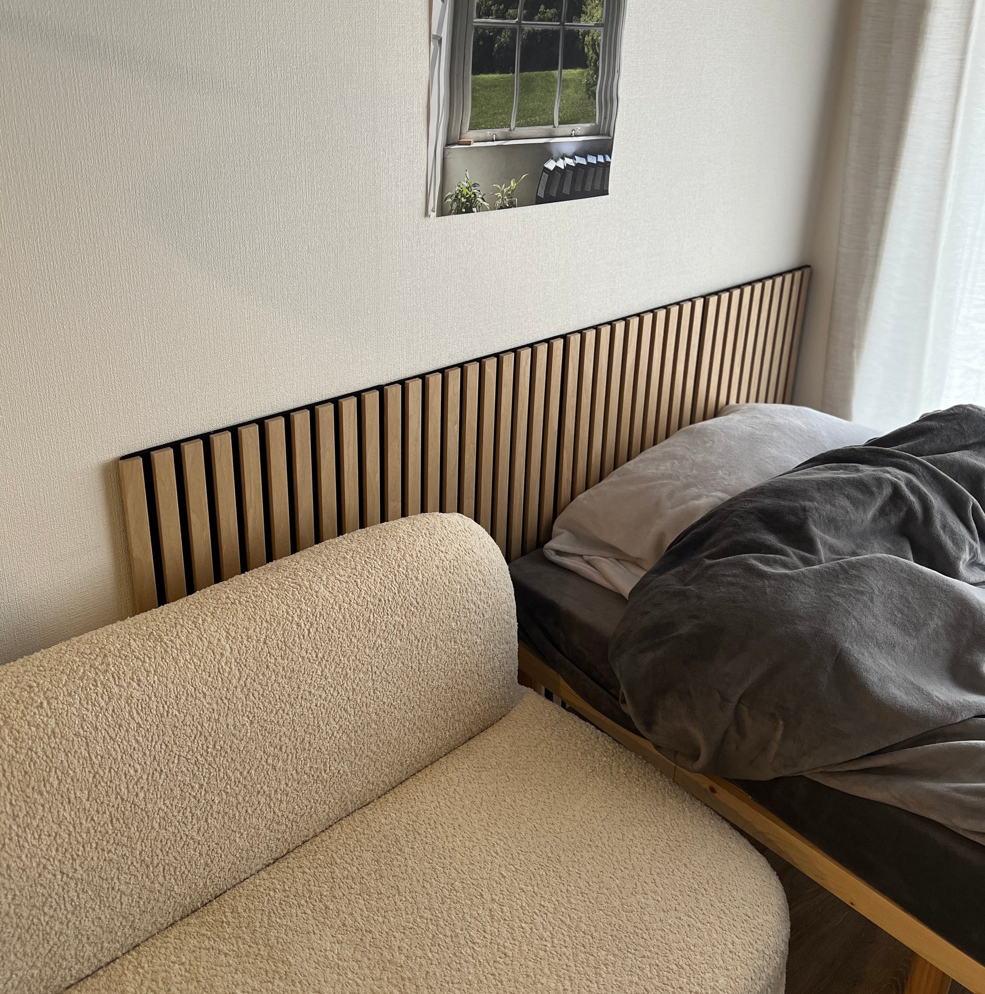 ナチュラルウッド調の吸音ウォールパネルを部屋に貼っている様子