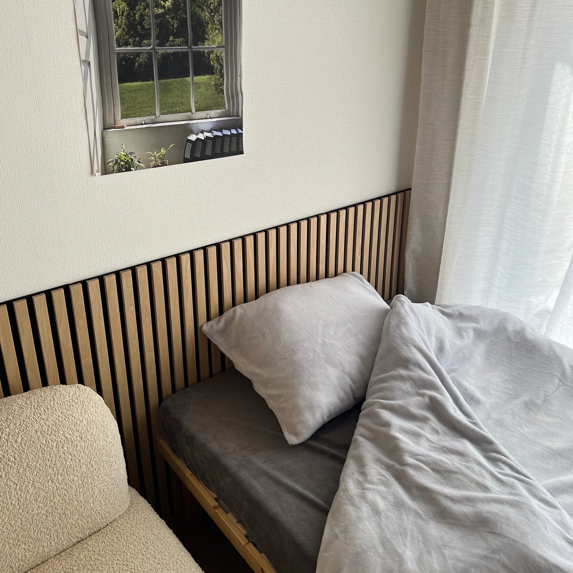 ６畳の空間にベッドとソファと吸音パネルが置いてある部屋