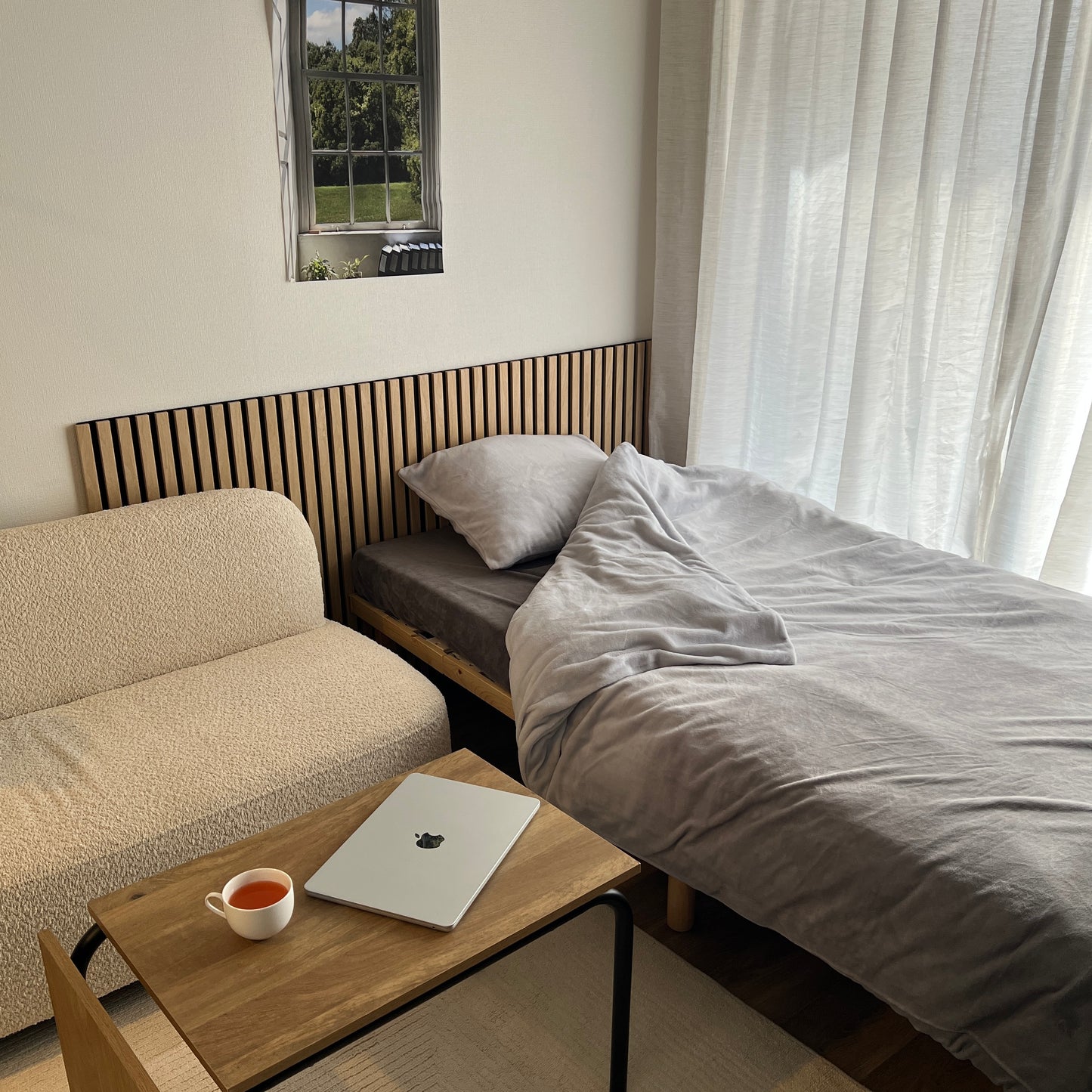 ６畳の空間にベッドとソファと吸音パネルが置いてある部屋