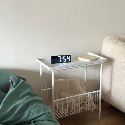 デジタルのアラーム時計がスサイドテーブルの上に置かれている様子