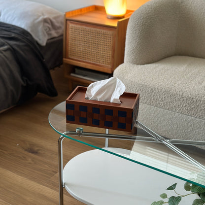 ブルーとブラウンの編み込みデザインのスクエア型ティッシュケースをクリアなテーブルに置いている様子