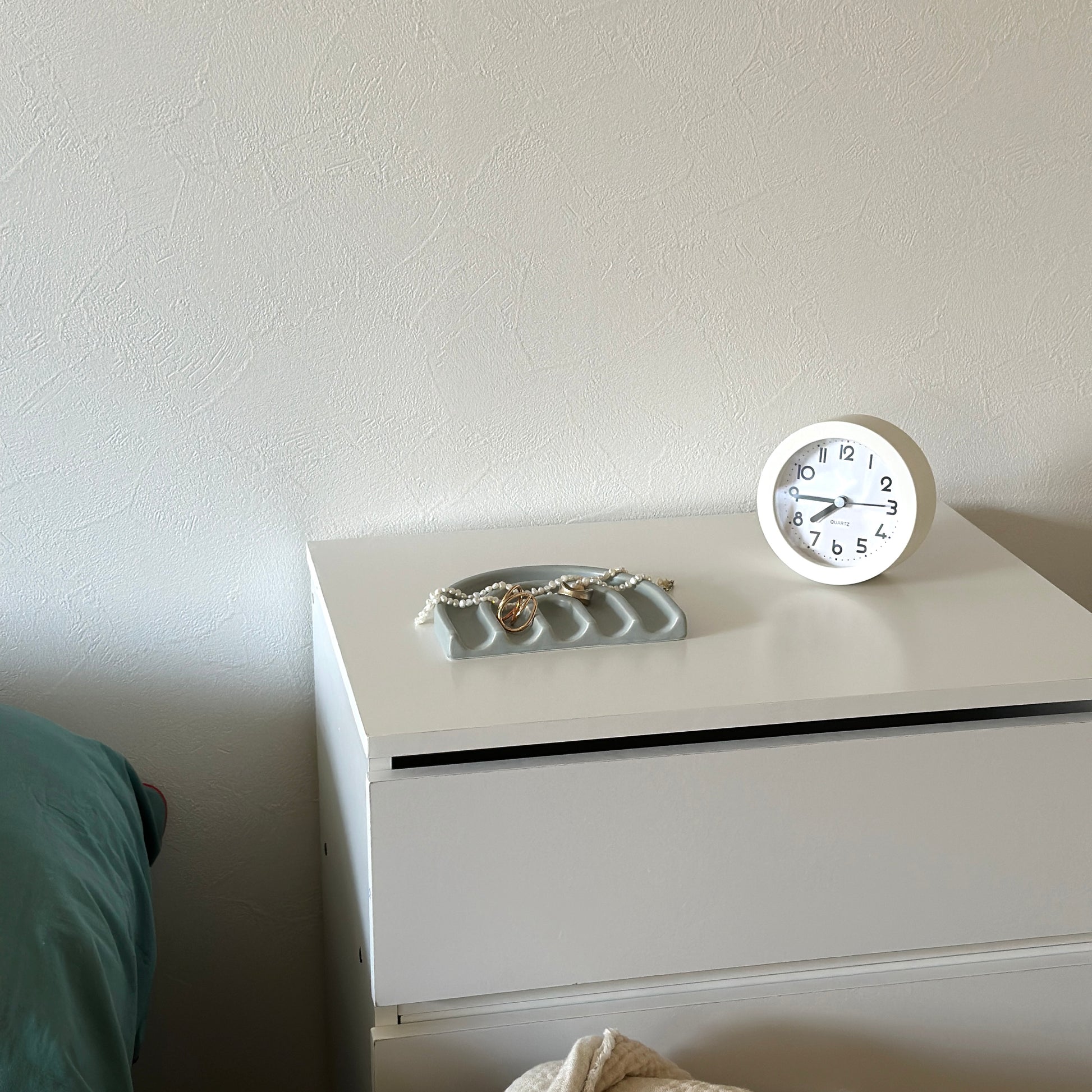 グレーのレインボーモチーフのプレートの上にアクセサリーが置かれてある様子