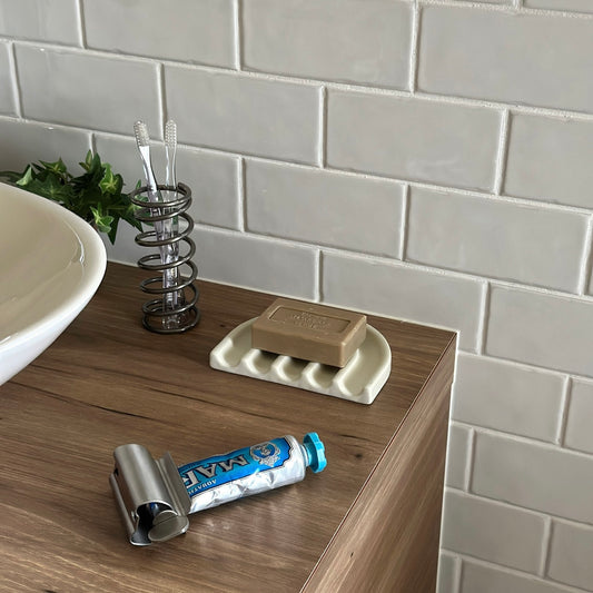 レインボーモチーフの薄黄色のプレートに茶色の石鹸が置かれてある様子