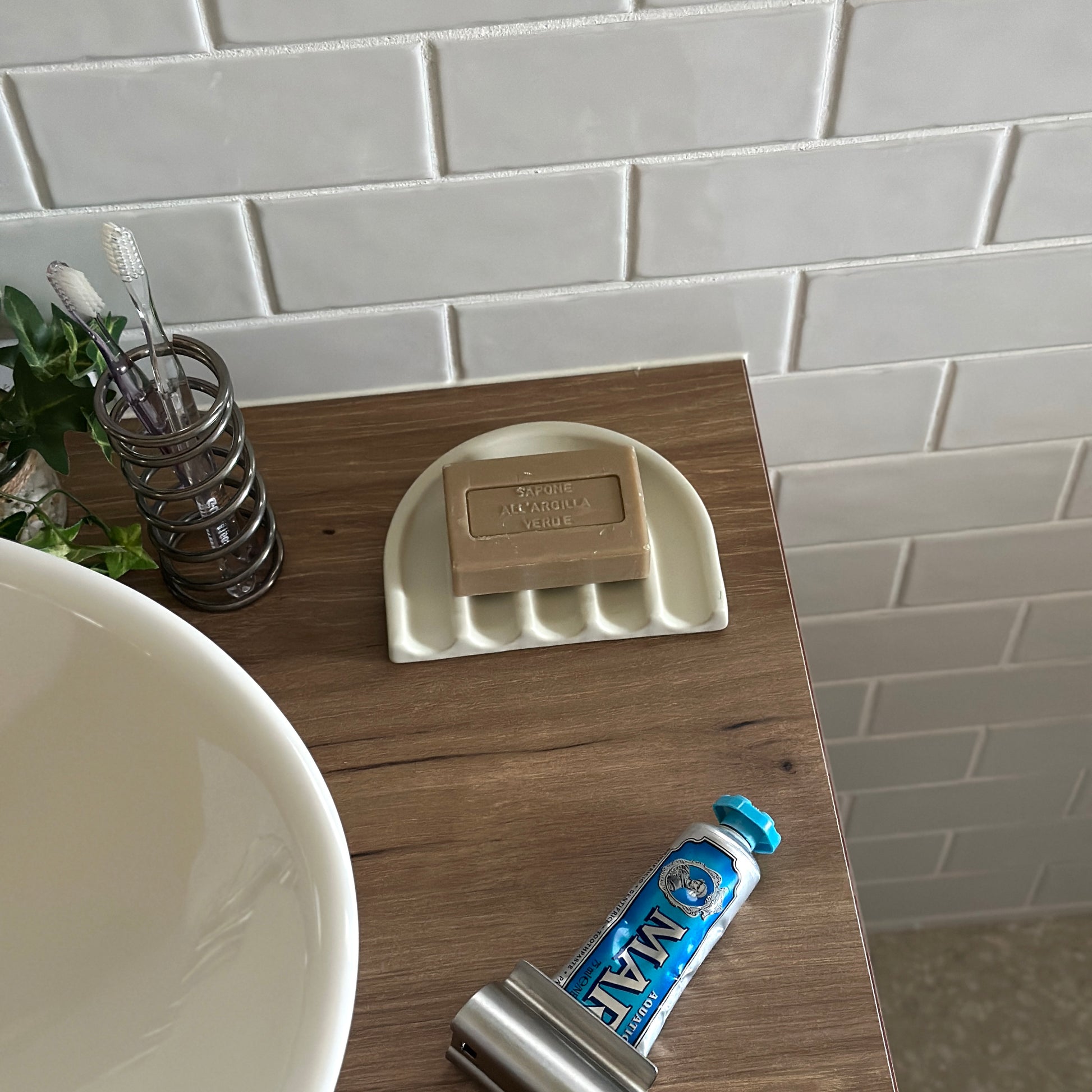 アイボリーのレインボーモチーフのプレートの上に茶色の石鹸が置かれてある様子