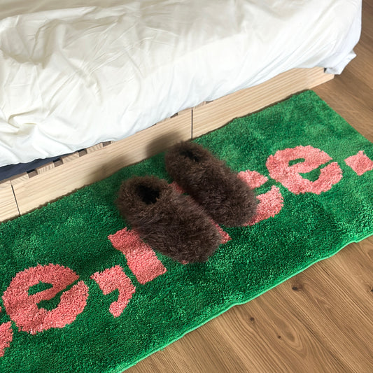 ブラウンのもこもこスリッパをベッド横に置いている様子