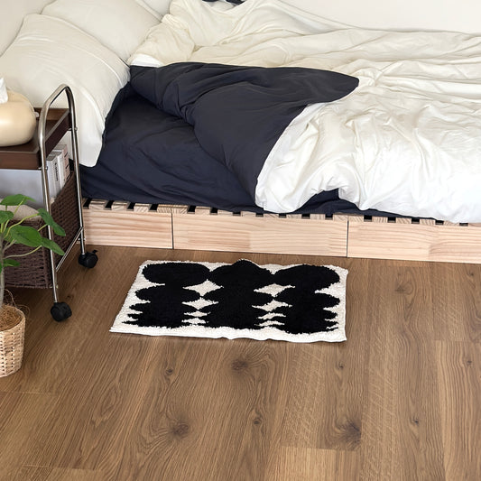 モノクロフェードのミニラグをベッド横に敷いている様子