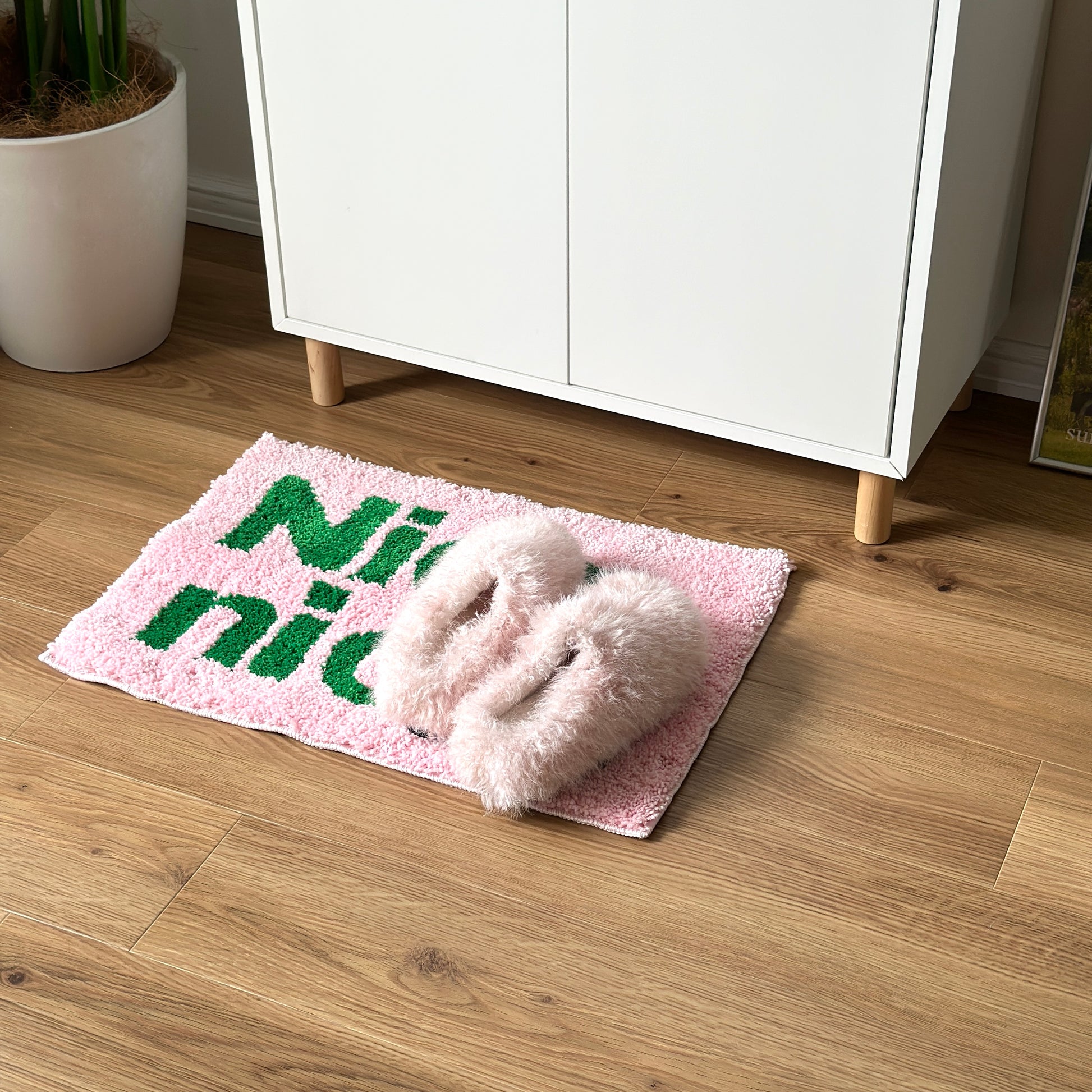 Nice,nice.のレタリングがされてあるピンクのミニラグの上にピンクのスリッパが置かれてある様子