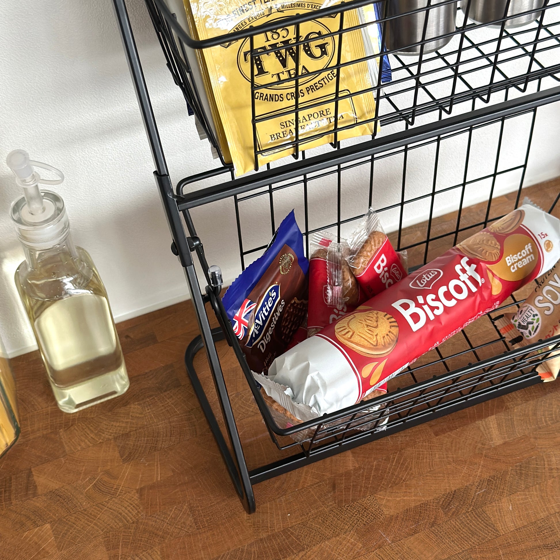 2段のブラックのワイヤーバスケットラックに食料品を入れている様子