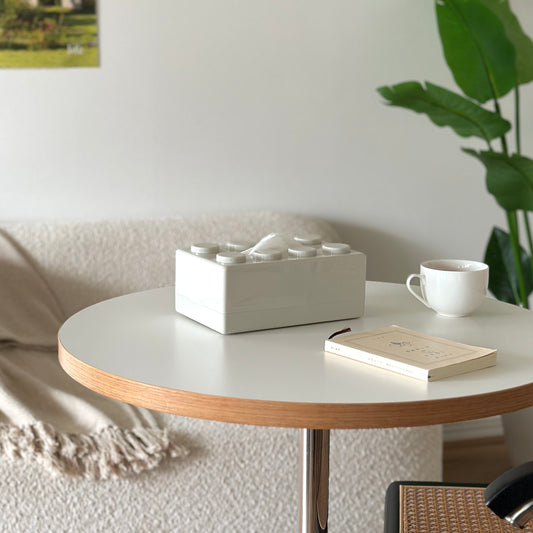 白い丸のテーブルに、白のブロックのティッシュケースが置かれてある。