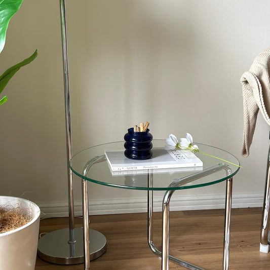 透明なガラステーブルの上にブルーのペン立てキャンドルホルダーが置かれてある。