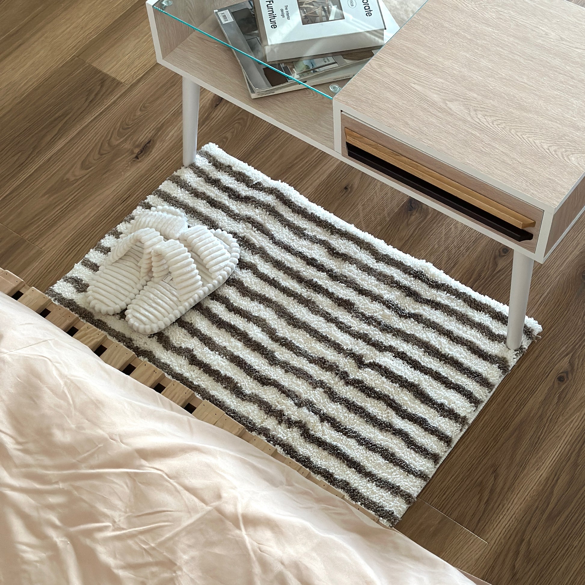 カーキのシンプルなボーダーミニラグをローテーブル前に敷いている様子