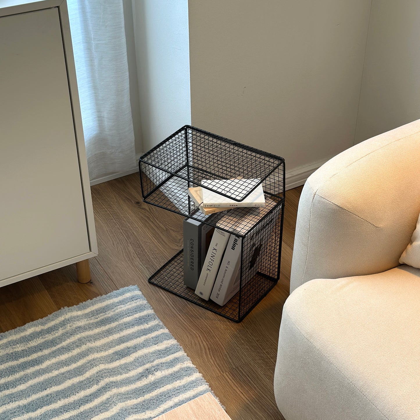 ブラックのメッシュデザインの収納ラックに本や雑誌を置いている様子