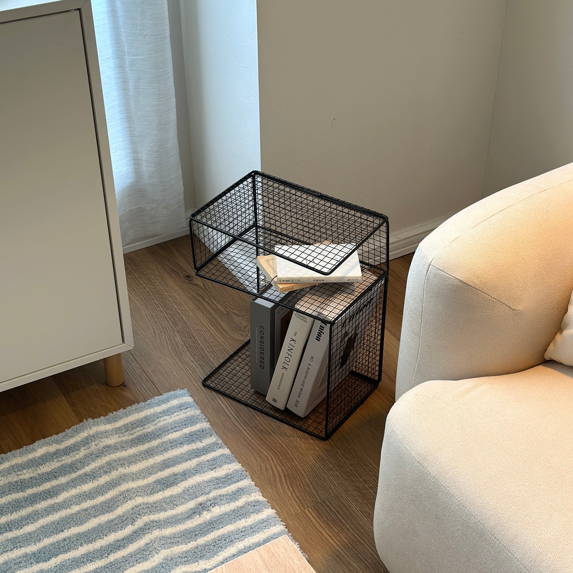 ブラックのメッシュデザインの収納ラックに本や雑誌を置いている様子