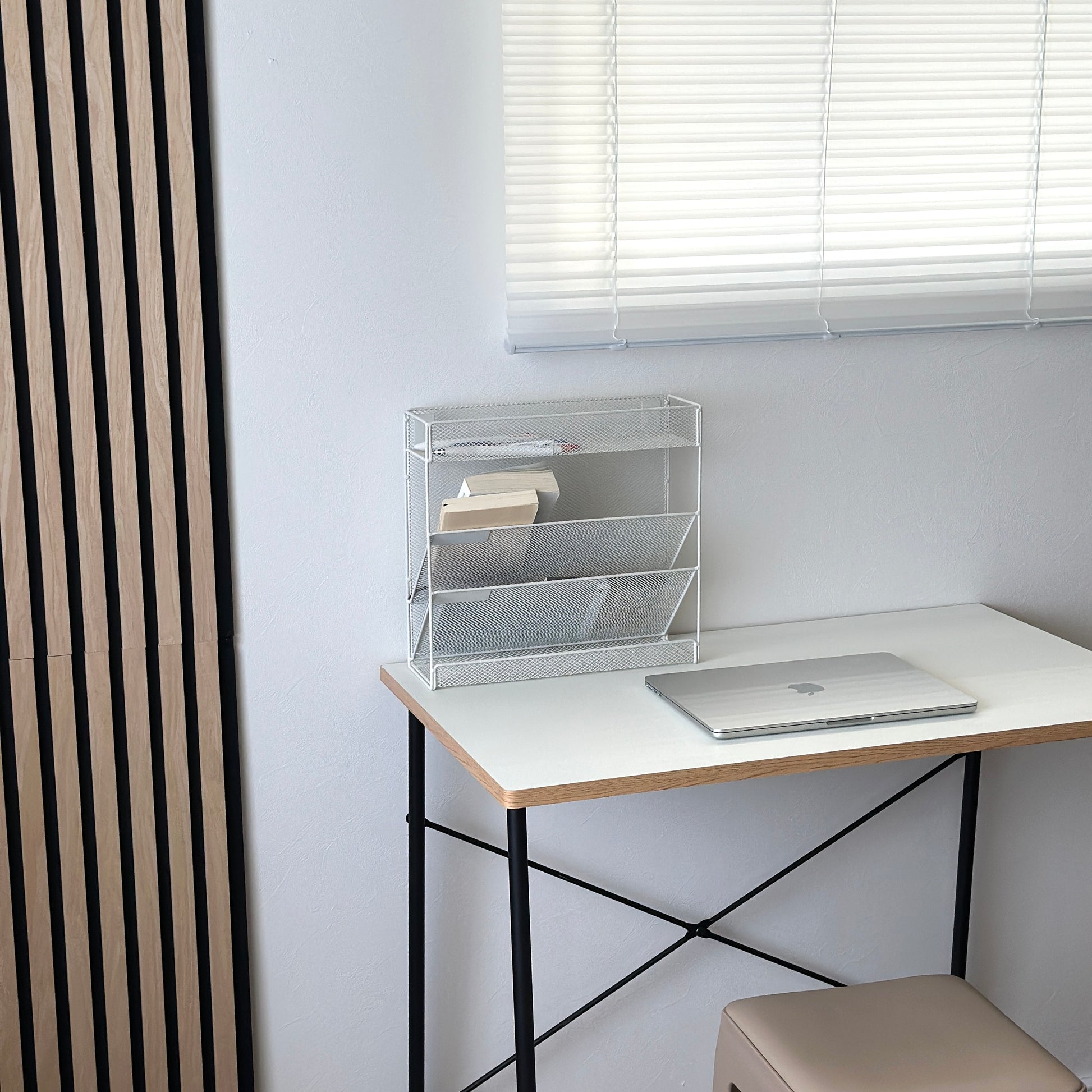 ホワイトのメッシュデザインの4段構造ラックをデスクに置いている様子