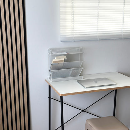 ホワイトのメッシュデザインの4段構造ラックをデスクに置いている様子