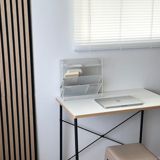 ホワイトのメッシュデザインの4段構造ラックをデスクに置いている様子