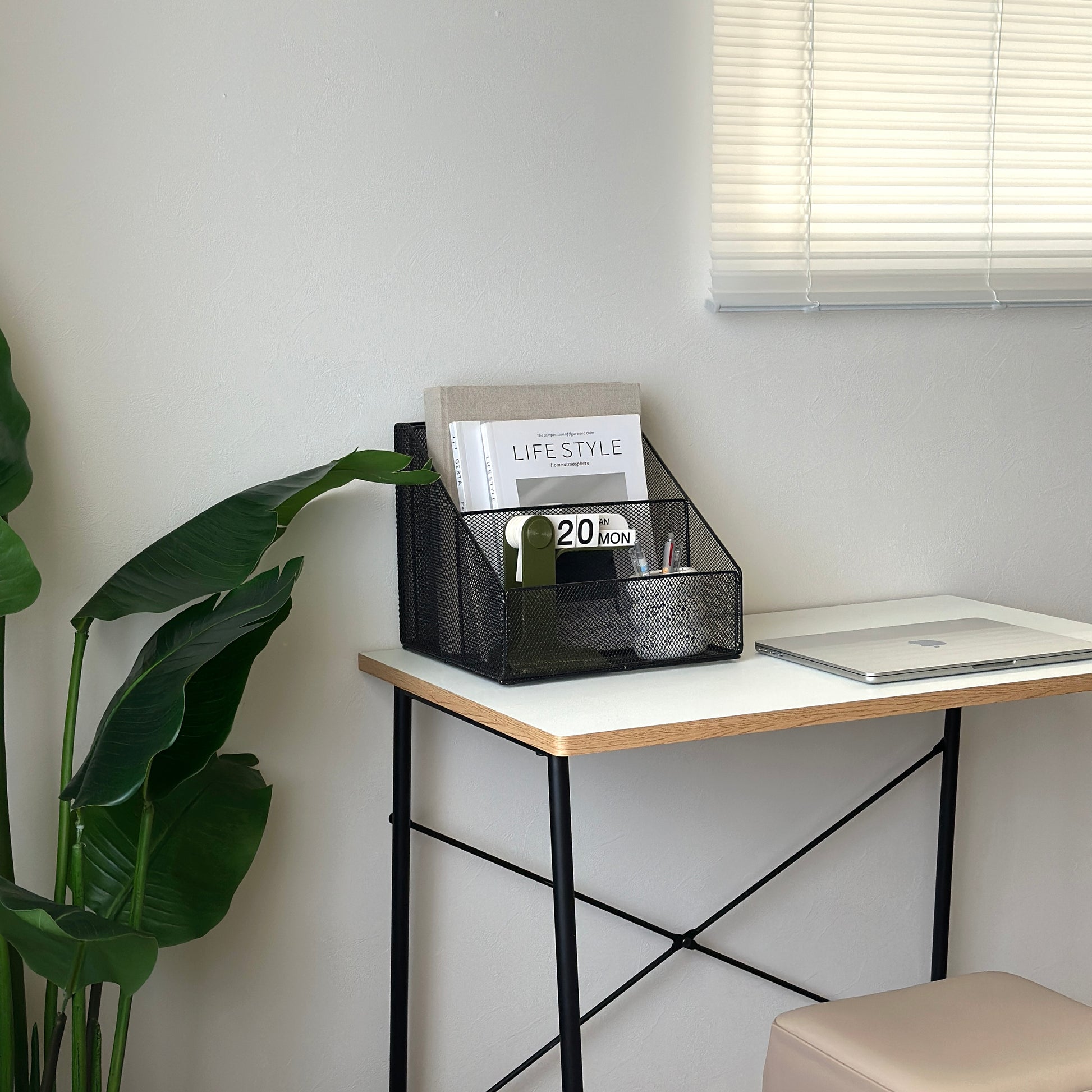 ブラックのアイアン素材のメッシュ収納ラックに雑誌や卓上カレンダー、ペンを入れている様子