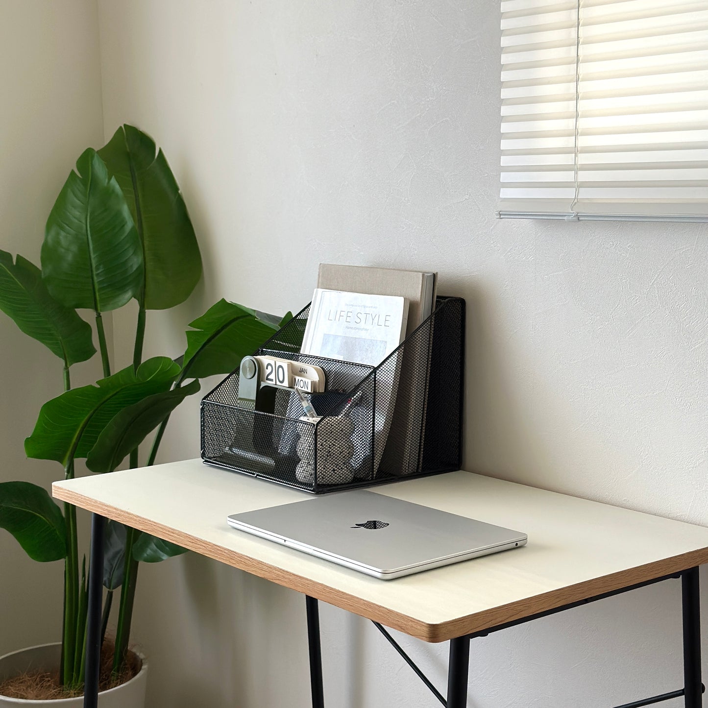 ブラックのアイアン素材のメッシュ収納ラックをデスクに置いている様子