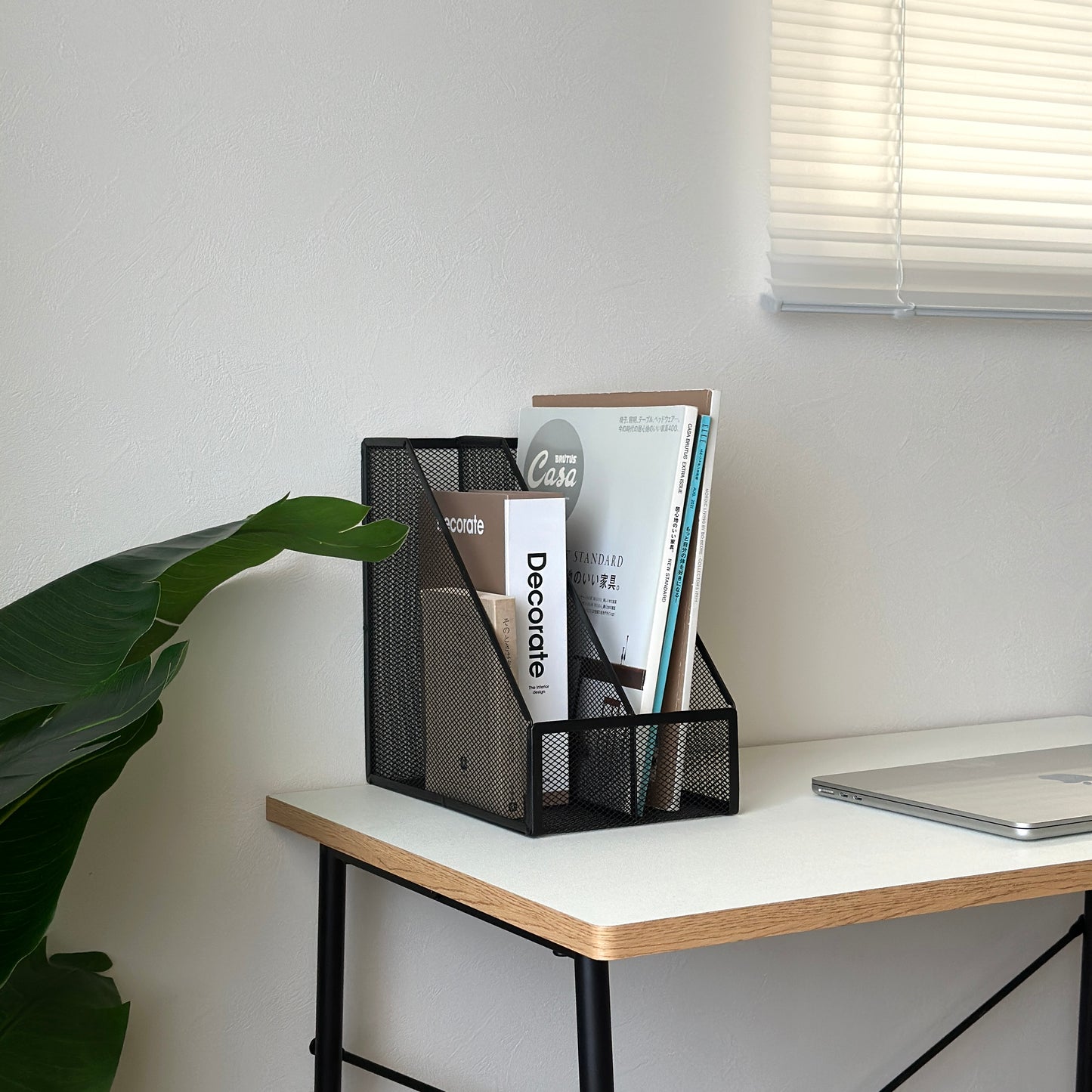 ブラックのアイアン素材のメッシュ収納ラックに雑誌や本を入れている様子