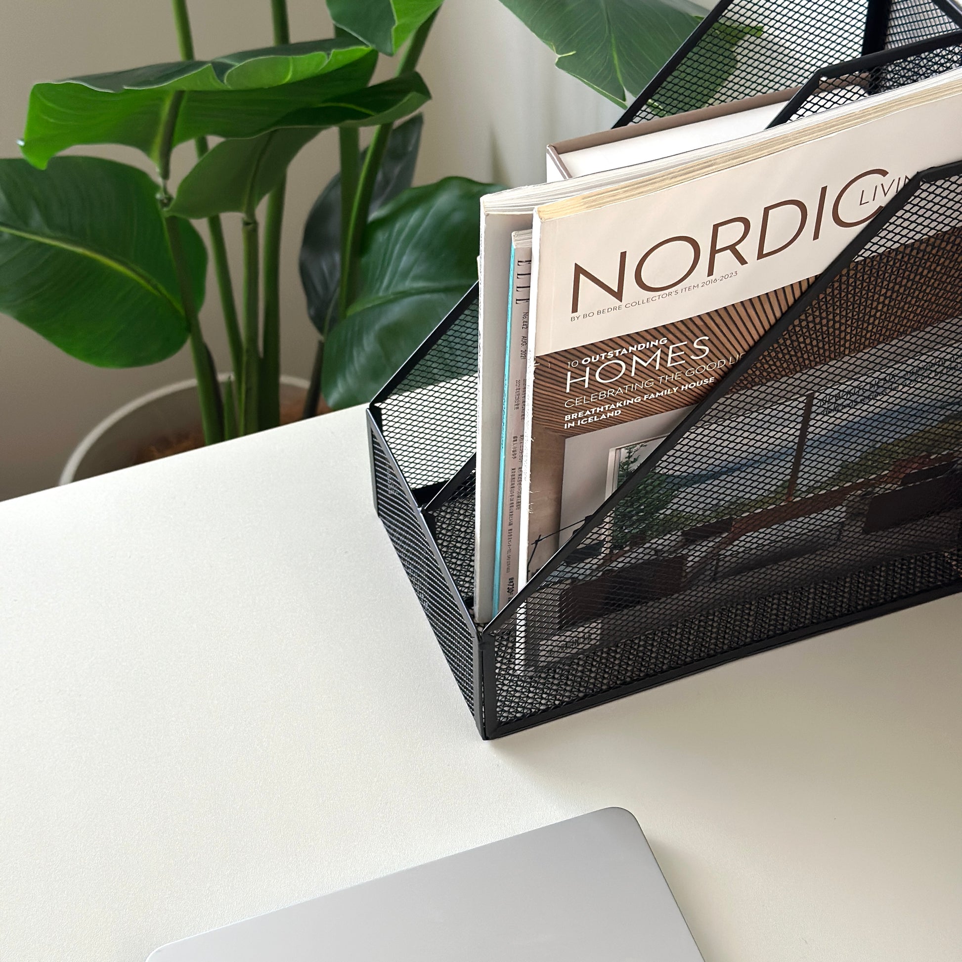 ブラックの卓上ブック収納ラックに雑誌を入れている様子