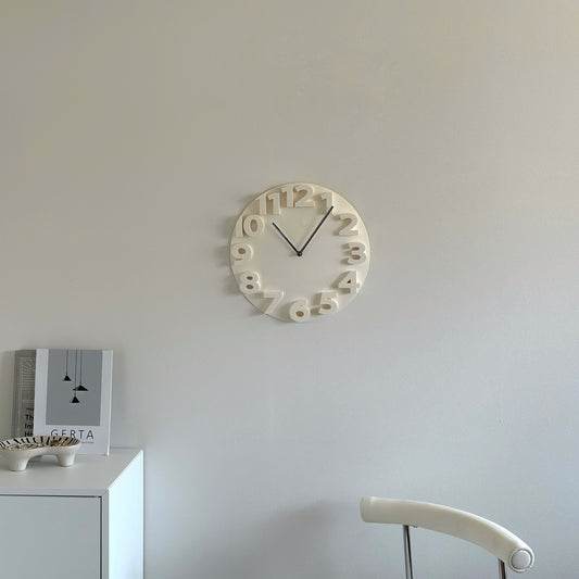 壁にかけられた文字盤が立体的なホワイトの掛け時計